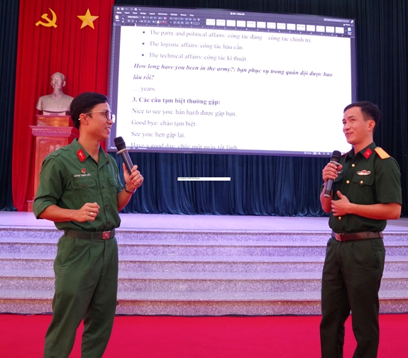 Hạ sĩ Huỳnh Trọng Hiếu (bên trái) giao lưu tiếng Anh với thành viên CLB tiếng Anh, Bộ CHQS tỉnh Long An.